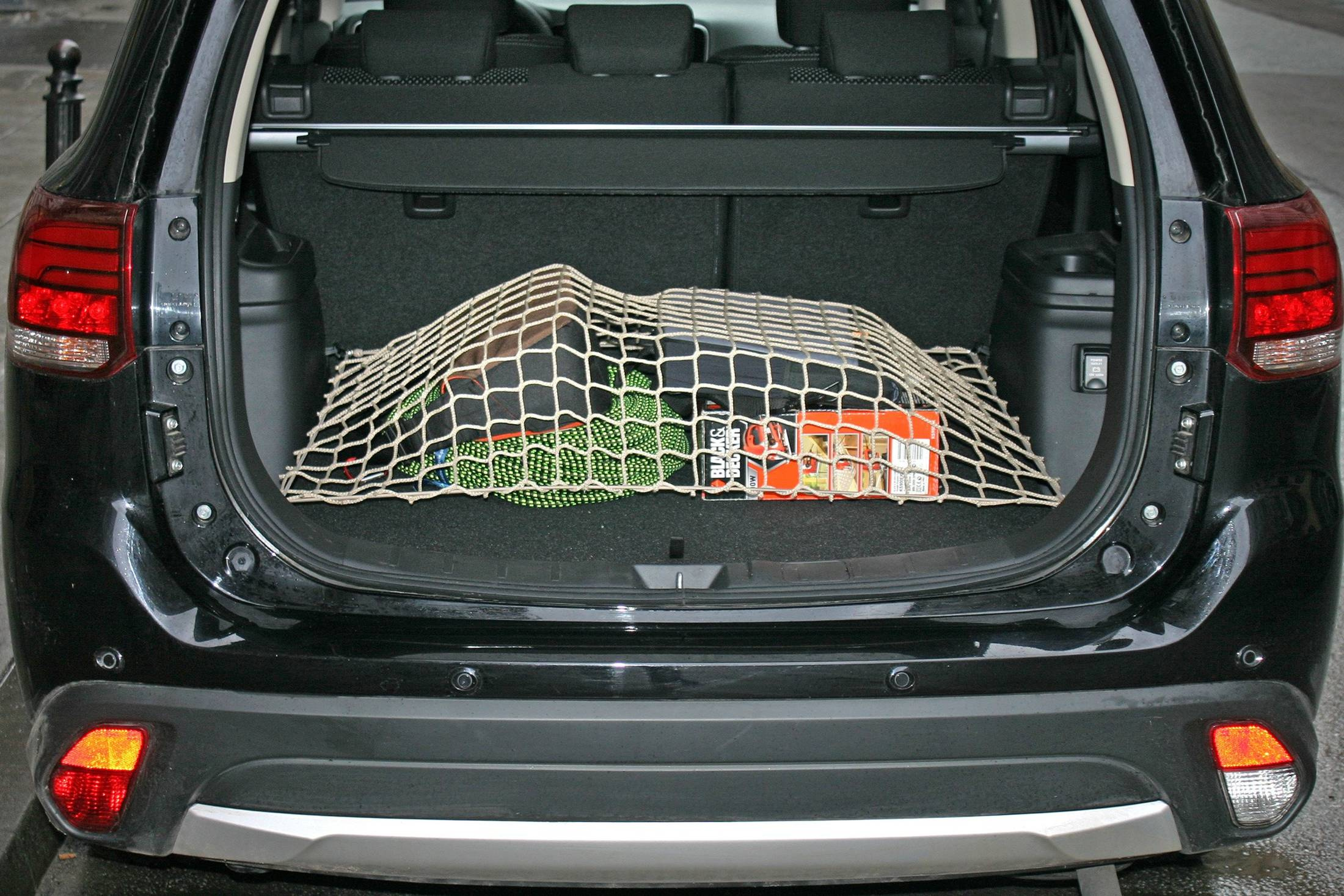 Beżowa siatka do bagażnika zabezpieczająca bagaż, dopasowana na wymiar.